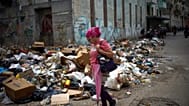 A woman walks past piles of rubbish on a street in Havana, Cuba, on Thursday, 19 March 2026. (AP Photo/Ramon Espinosa)