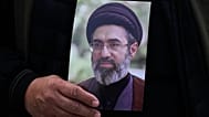رجل يحمل صورة مجتبى خامنئي خلال تشييع الجنرال علي محمد نائيني في طهران، 21 مارس/آذار 2026.