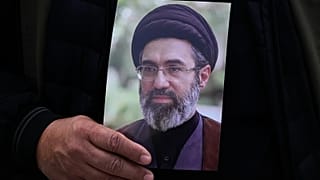 رجل يحمل صورة مجتبى خامنئي خلال تشييع الجنرال علي محمد نائيني في طهران، 21 مارس/آذار 2026.