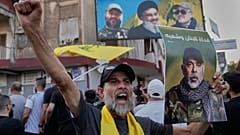 مناصر لحزب الله يحمل صورة رئيس أركان الحزب هيثم طبطباي في ضاحية بيروت الجنوبية، 24 نوفمبر/تشرين الثاني 2025.