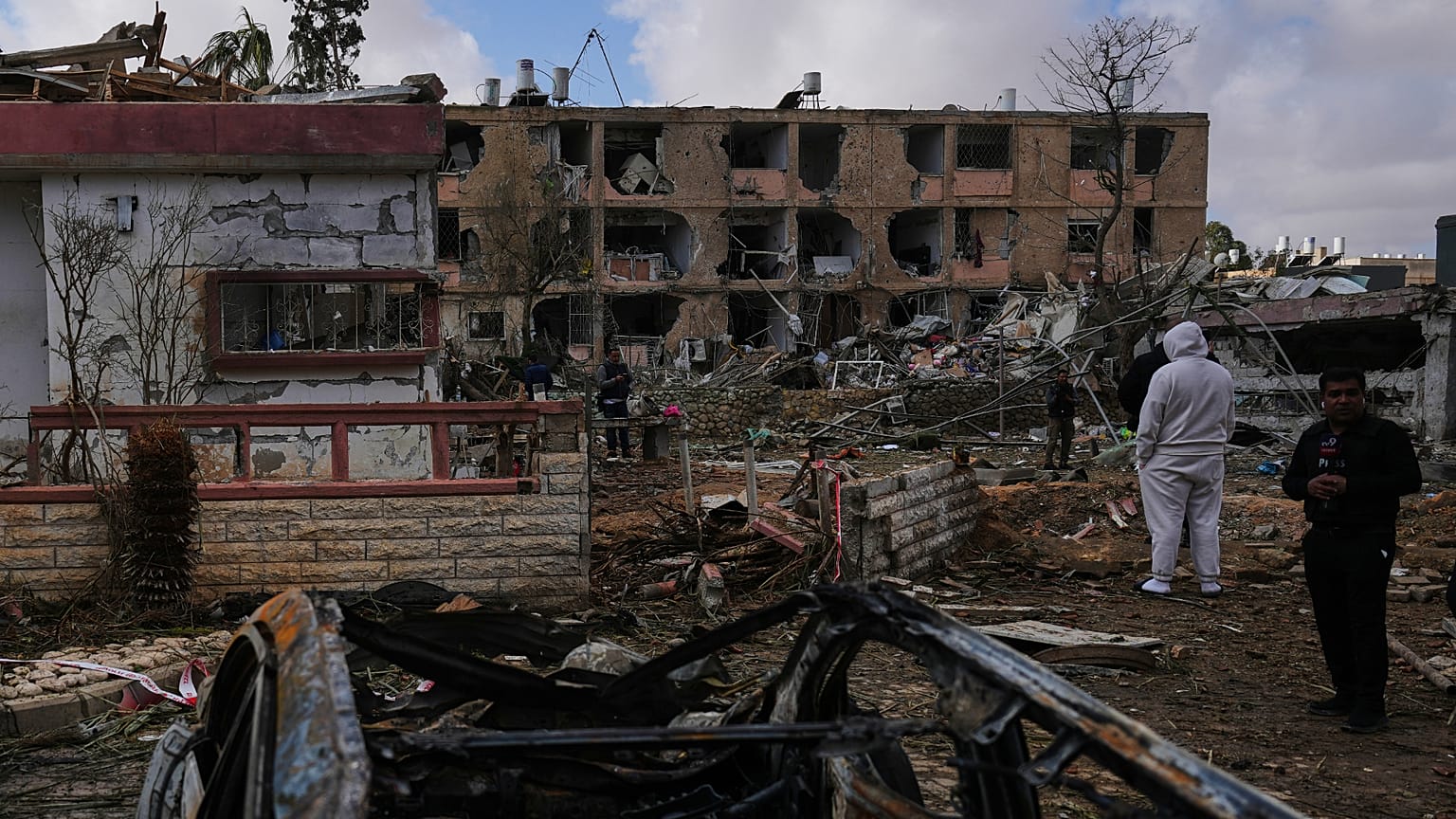 Des personnes sur un site touché par un missile iranien à Dimona, dans le sud d'Israël, le dimanche 22 mars 2026.