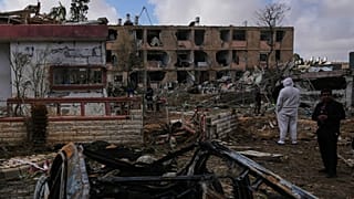 Des personnes sur un site touché par un missile iranien à Dimona, dans le sud d'Israël, le dimanche 22 mars 2026.