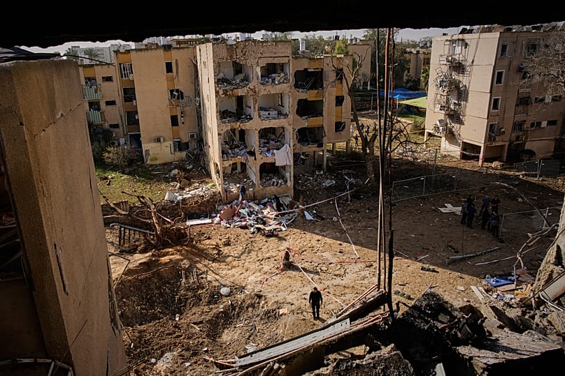 People look at residential buildings damaged by an Iranian missile strike in Arad, southern Israel, Sunday, March 22, 2026.