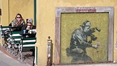 Sundance katılımcıları, 2010 yılındaki festivalde yapılan Banksy imzalı 'Kameraman ve Çiçek' duvar resminin hemen yanındaki kafede.