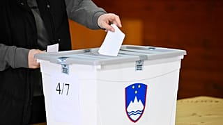 Une électrice dépose son bulletin dans un bureau de vote lors des élections législatives à Arnace, en Slovénie, le dimanche 22 mars 2026.