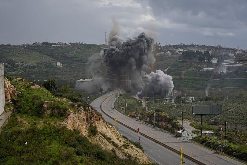  يتصاعد الدخان واللهب من غارة جوية إسرائيلية استهدفت جسر القاسمية بالقرب من مدينة صور الساحلية في لبنان، يوم الأحد 22 مارس/آذار 2026.
