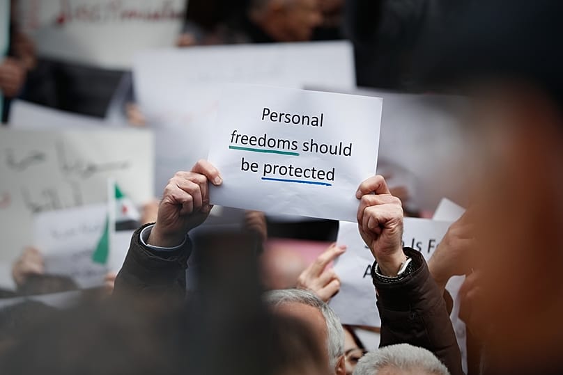 متظاهرون يحملون لافتات خلال مظاهرة ضد القيود الجديدة المفروضة على بيع الكحول في دمشق، سوريا، الأحد 22 مارس/آذار 2026. 