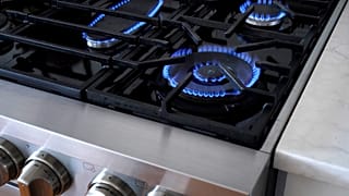 Flames emerge from burners on a natural gas stove.