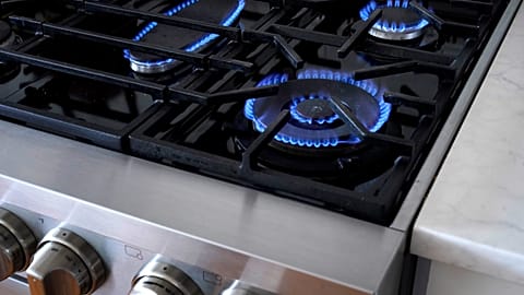 Flames emerge from burners on a natural gas stove.