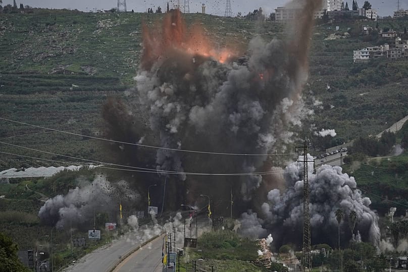 Smoke and flames rise from an Israeli airstrike that hit the Qasmiyeh Bridge near the coastal city of Tyre, Lebanon, Sunday, March 22, 2026. (AP Photo/Mohammad Zaatari)