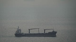 A cargo ship carrying vehicles sails through the Gulf toward the Strait of Hormuz in the United Arab Emirates, 22 March 2026