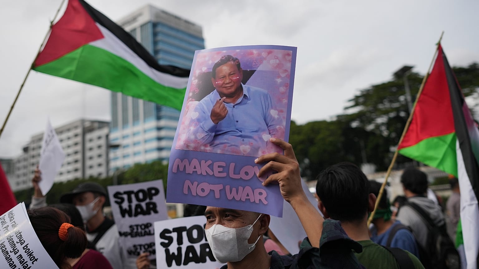  متظاهر يعرض ملصقاً للرئيس الإندونيسي برابوو سوبيانتو خلال مسيرة احتجاجية ضد مشاركة بلاده في مجلس السلام الذي تقوده الولايات المتحدة