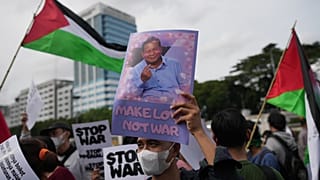  متظاهر يعرض ملصقاً للرئيس الإندونيسي برابوو سوبيانتو خلال مسيرة احتجاجية ضد مشاركة بلاده في مجلس السلام الذي تقوده الولايات المتحدة