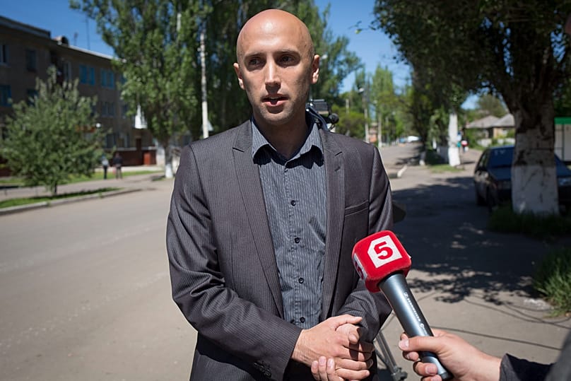 In this photo taken on Wednesday, May 7, 2014, video journalist Graham Phillips speaks to his colleagues at the Ukraine hotel in Slovyansk, Ukraine. 