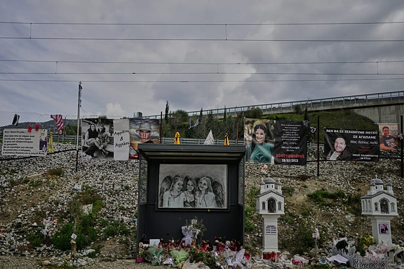 Banners, portraits and miniature churches are placed in memory of the victims at the site of the Tempi train disaster in Tempi, 23 March, 2026