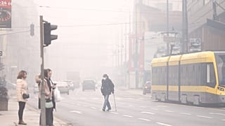 Ein Mann mit Atemschutzmaske überquert in Sarajevo die Straße, dichter Smog verschleiert am Mittwoch, 22. Januar 2025, die bosnische Hauptstadt.
