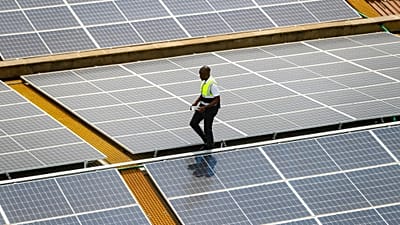 ARCHIVO - Mark Munyua, técnico de CP Solar, revisa paneles solares en el tejado de una empresa en Nairobi, Kenia, el 1 de septiembre de 2023.