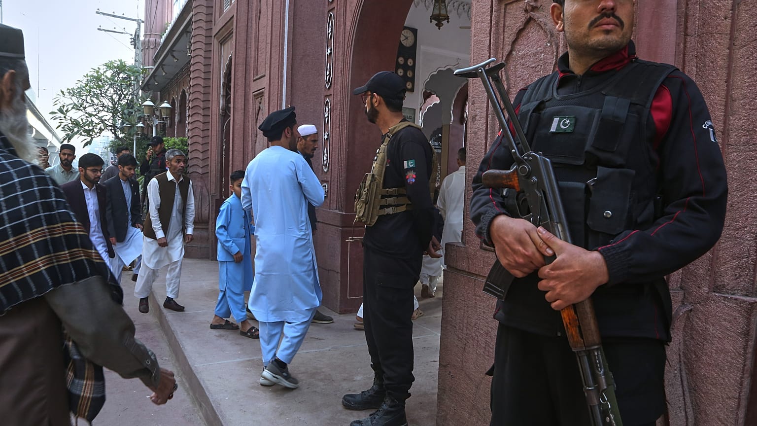 يقف رجال الشرطة في حالة تأهب بينما يصل الناس لحضور صلاة عيد الفطر بمناسبة انتهاء شهر رمضان المبارك، في بيشاور، باكستان، يوم السبت 21 مارس 2026. (صورة من وكالة أسوشيتد برس/محمد