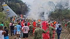 Menschen stehen um ein Militärtransportflugzeug, das kurz nach dem Start bei Puerto Leguízamo in Kolumbien abgestürzt ist.