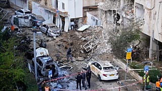 Israeli security and rescue forces respond at the site of an Iranian missile strike in Tel Aviv, 24 March 2026