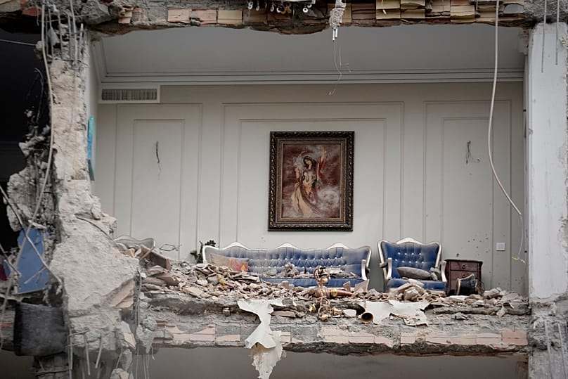 Rubble covers the furniture of a destroyed living room in a residential building hit in Tehran, 23 March, 2026