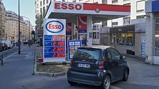 A car drives into a gas station as gasoline prices are displayed in Paris, Monday, March 9, 2026