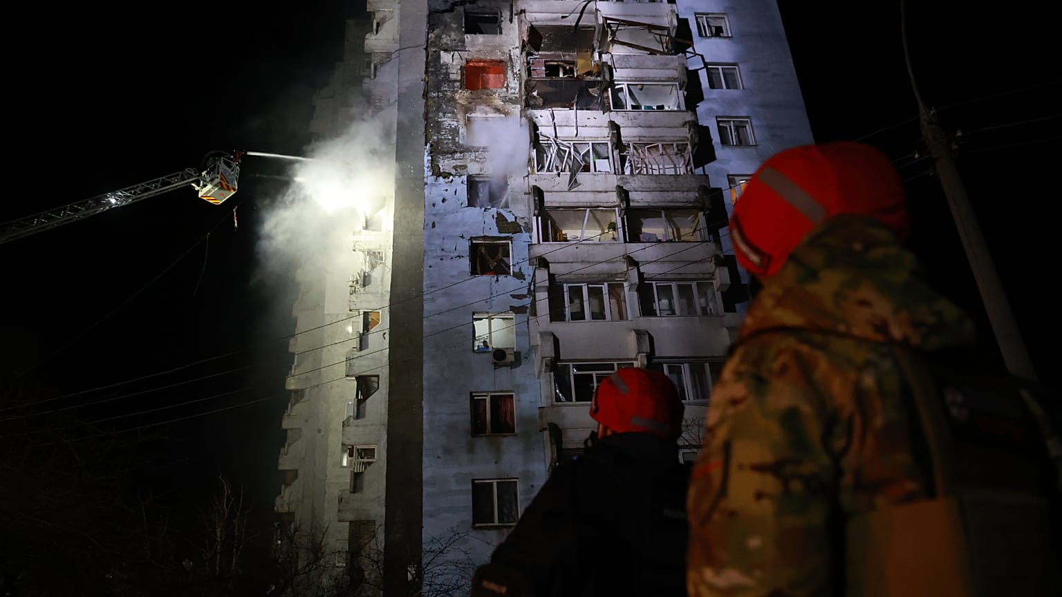 Kurtarma görevlileri, 24 Mart 2026 Salı günü Ukrayna'nın Zaporizhzhia kentinde Rus insansız hava aracının saldırısının ardından yanan bir konut binasındaki yangını söndürmeye çalışıyor.