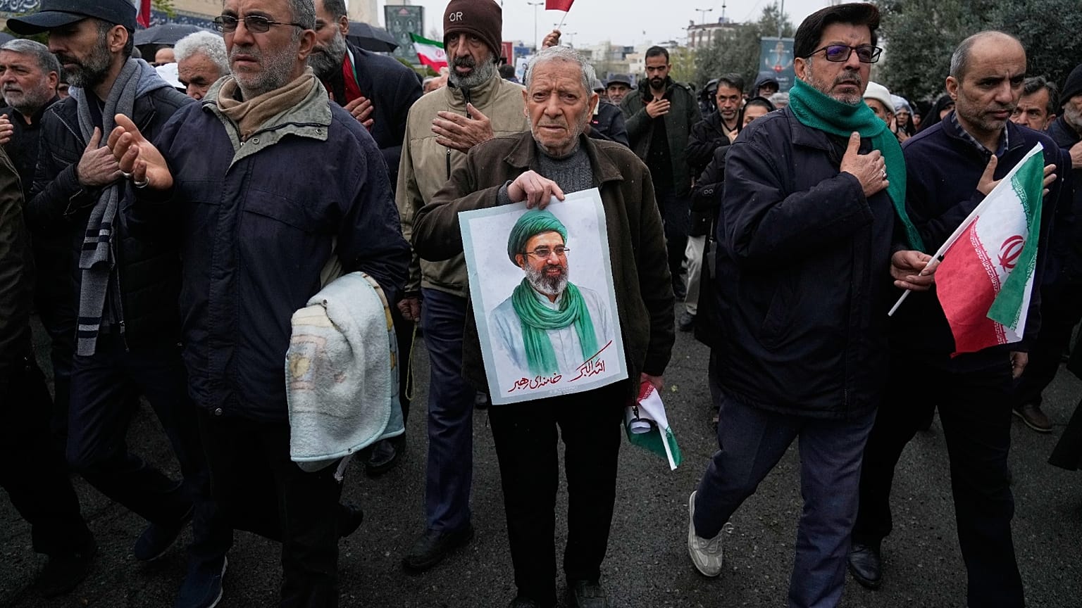 شخص يحمل ملصقًا للمرشد الأعلى آية الله مجتبى خامنئي خلال موكب جنازة وزير المخابرات الإيراني إسماعيل الخطيب وزوجته وابنته، إيران، الجمعة 20 مارس