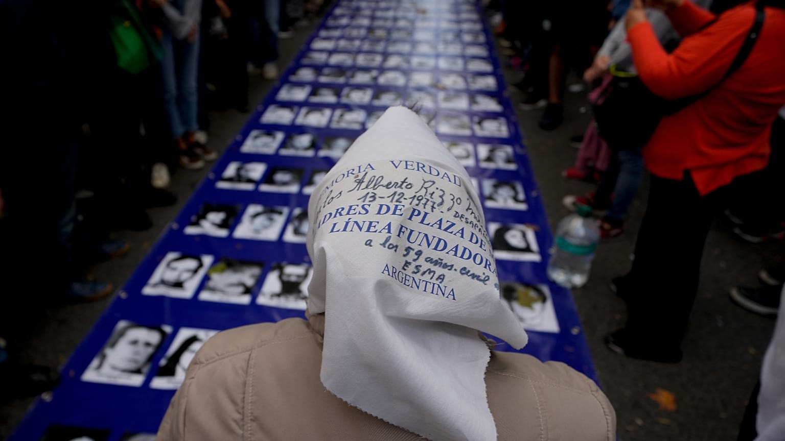 ARCHIVO: Adelina Molina, miembro de Madres de Plaza de Mayo, frente a fotografías de las víctimas de la dictadura durante una marcha en Buenos Aires, el 24 de marzo de 2022.