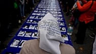 ARCHIVO: Adelina Molina, miembro de Madres de Plaza de Mayo, frente a fotografías de las víctimas de la dictadura durante una marcha en Buenos Aires, el 24 de marzo de 2022.