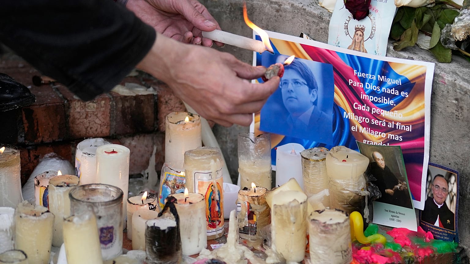 Un hombre enciende velas en un altar que fue erigido en honor del senador colombiano Miguel Uribe Turbay, en Bogotá, el 18 de junio de 2025.