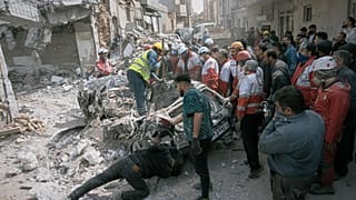 I soccorritori sul luogo di un edificio residenziale colpito da un attacco aereo notturno, Tabriz, Iran nord-occidentale, 24 marzo 2026