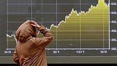 In Tokio betrachtet eine Person am Montag, 23. März 2026, bei einer Wertpapierfirma eine elektronische Anzeigetafel mit dem Nikkei-Index.