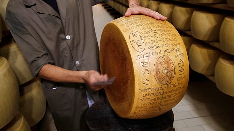 ARCHIVO - Un empleado de control de calidad inspecciona un queso Parmigiano Reggiano en Noceto, Parma, Italia. 8 de octubre de 2019.