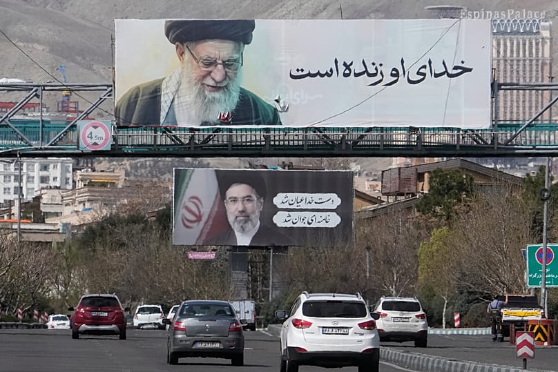 Vehicles drive under billboards showing portraits of the late Iranian Ayatollah Ali Khamenei, foreground, and his son Mojtaba Khamenei, in Tehran, 24 March 2026