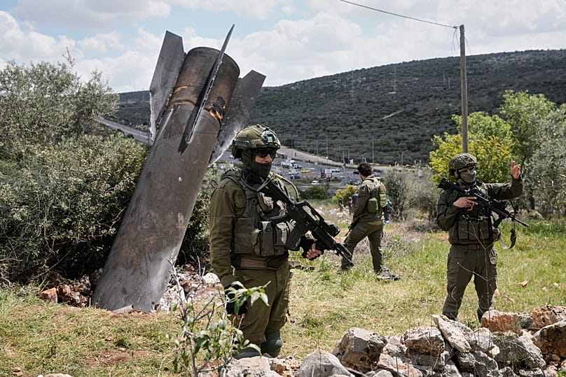 Israeli soldiers secure the site where an Iranian missile wreckage landed in the West Bank village of Kifl Haris, 24 March 2026