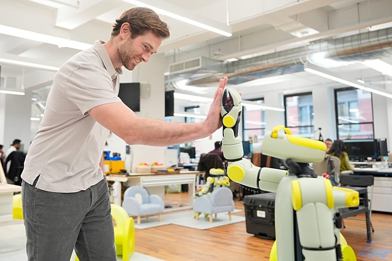 Fauna Robotics'in kurucu ortağı ve CEO'su Rob Cochran, şirketin robotu Sprout'la ABD'nin New York kentindeki ofislerinde, Ocak 2026'da beşlik çakıyor.