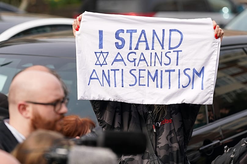 A protester holds a banner at Golders Green in London, 23 March, 2026