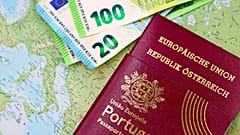 Πορτογαλικό διαβατήριο και χαρτονομίσματα ευρώ πάνω σε παγκόσμιο χάρτη