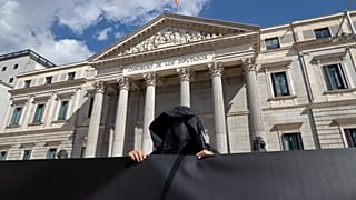 Un manifestante contrario a la eutanasia se encuentra frente al Parlamento español en Madrid, España, el jueves 18 de marzo de 2021