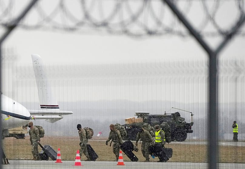 جنود من الفرقة 82 المحمولة جواً التابعة للجيش الأمريكي يُنزلون مركبات من طائرة نقل بعد وصولها من قاعدة فورت براغ الى مطار بولندا، يوم الأحد 6 فبراير/شباط 2022