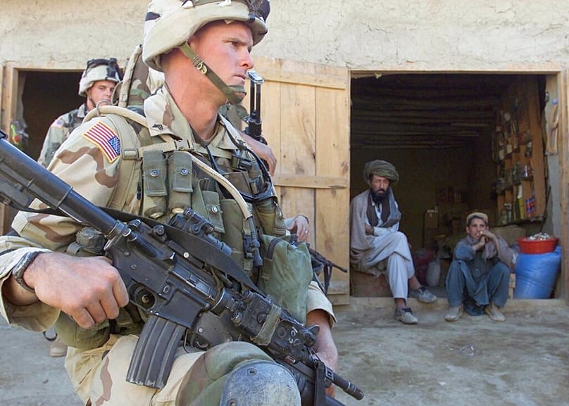  جنود أمريكيون، من الفرقة 82 المحمولة جواً، يؤمّنون منطقة قرب متجر صغير، بولاية بكتيا، جنوب كابول، أفغانستان، يوم الخميس 14 نوفمبر/تشرين الثاني 2002. 