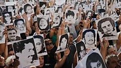 Manifestantes exhiben fotografías de personas desaparecidas durante la dictadura militar argentina (1976-1983) en una concentración por el aniversario del golpe de Estado.