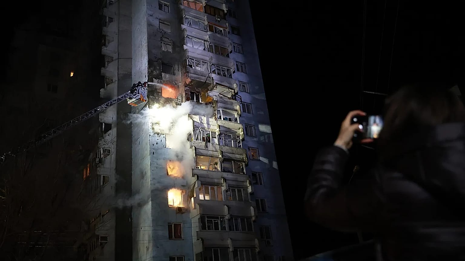 Rescue workers try to put out a fire of a residential building burning after a Russian drone attack on Zaporizhzhia, 24 March, 2026