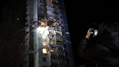 Kurtarma görevlileri, Rus insansız hava aracının Zaporijya'ya düzenlediği saldırının ardından yanan bir konut binasındaki yangını söndürmeye çalışıyor, 24 Mart, 2026