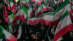  أنصار الحكومة يلوحون بالأعلام الإيرانية خلال مسيرة في ساحة غرب طهران، إيران، الأربعاء 25 مارس/آذار 2026.