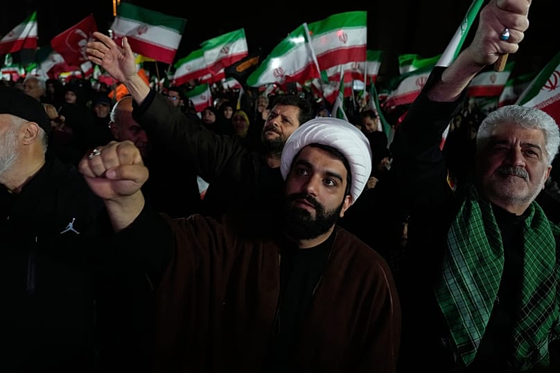  رجل دين ومتظاهرون آخرون يهتفون بشعارات خلال تجمع مؤيد للحكومة في ساحة غرب طهران، إيران، الأربعاء 25 مارس/آذار 2026. 