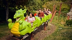 Familien fahren mit der Achterbahn „Dragon's Apprentice“ im LEGOLAND Windsor Resort.