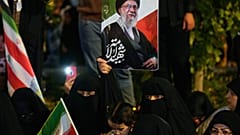 نساء مسلمات عراقيات يحملن ملصقًا للمرشد الأعلى الإيراني الراحل آية الله علي خامنئي خلال مسيرة يوم القدس السنوية لدعم الفلسطينيين