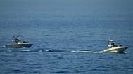 FILE: Iranian Revolutionary Guard vessels watch an American warship in the Strait of Hormuz, 19 May 2023